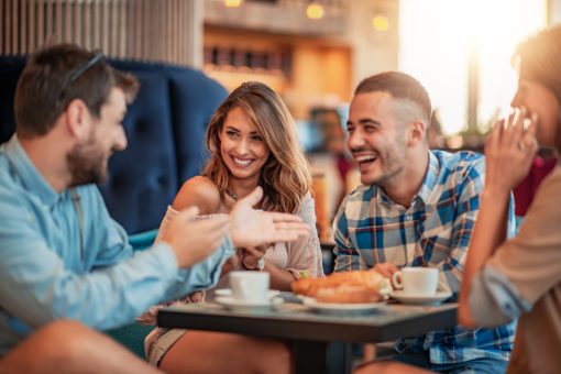 Happy,Friends,Having,A,Great,Time,In,Cafe.,Friends,Sitting Amigos sonríen y comen